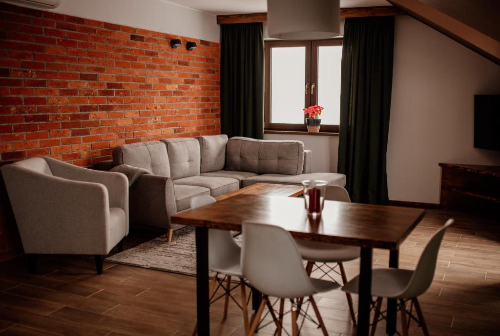 een woonkamer met een bank en een tafel bij Apartament z widokiem Azyl Widoki in Wielkie Leżno