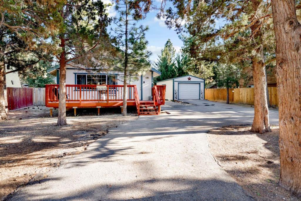 a driveway leading to a house with a fence and trees at Montana Cabin - 1938 by Big Bear Vacations in Big Bear City