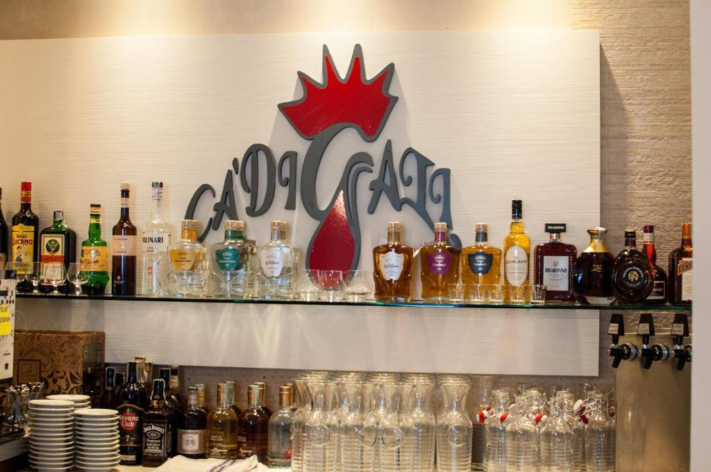 un bar con molte bottiglie e bicchieri su uno scaffale di Hotel Ca' di Gali a Sasso Marconi