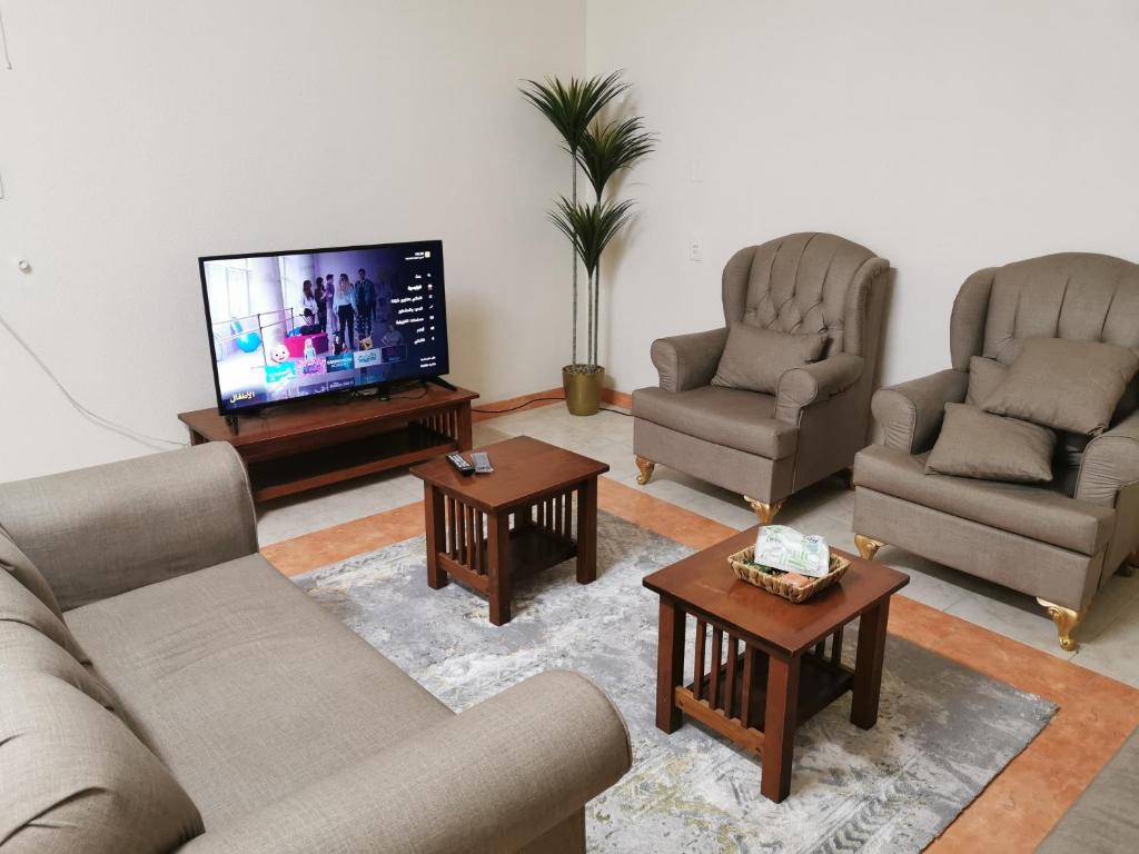 a living room with three couches and a flat screen tv at شقق عائلية مع انترنت مجاني in Al Ahsa