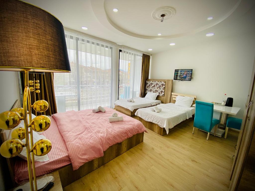 una camera con letto, divano e tavolo di Hotel Perla a Prizren