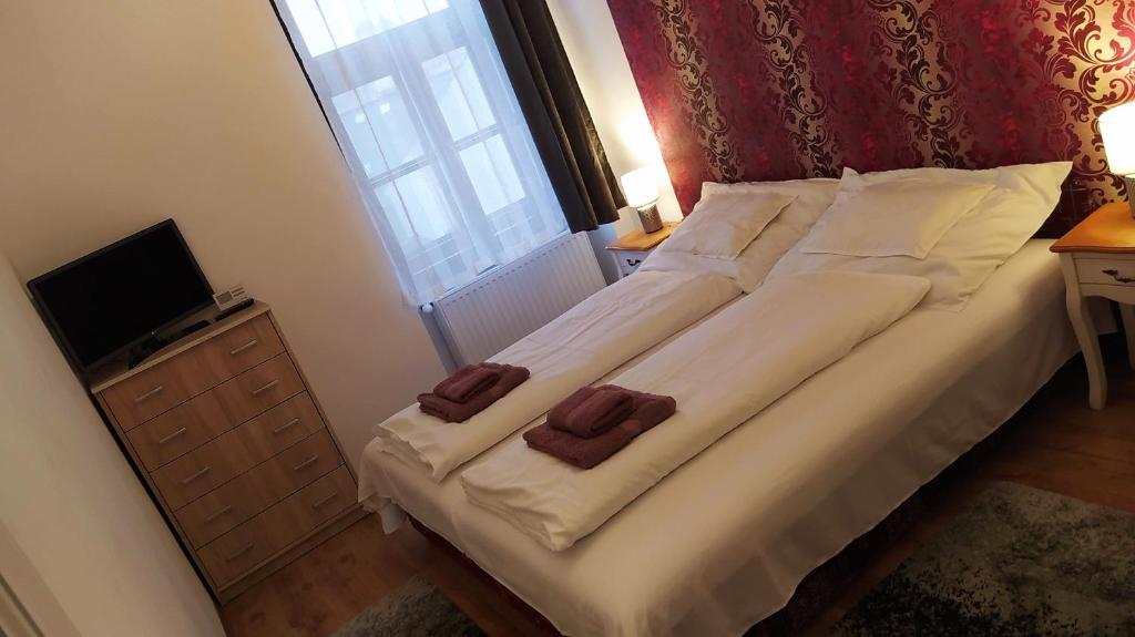 エゲルにあるAranyvár Apartmentのベッドルーム1室(大型ベッド1台、タオル2枚付)
