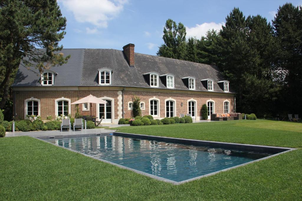 a large house with a swimming pool in front of it at B&B L'Orangerie in Waterloo