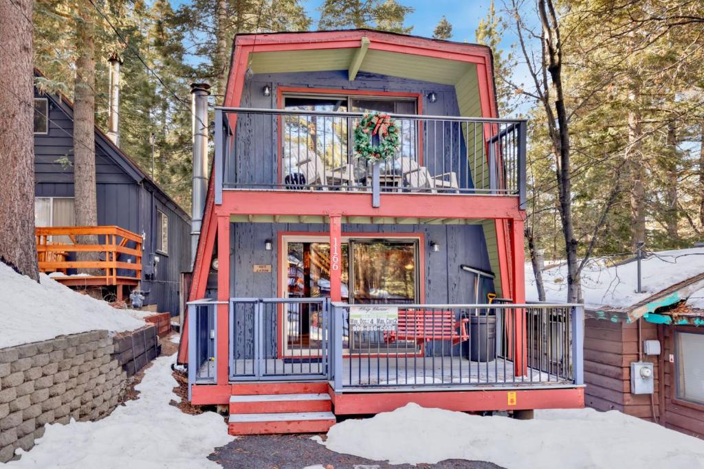 ein kleines Haus mit Balkon im Schnee in der Unterkunft Wolf Cub Cabin - 1946 by Big Bear Vacations in Big Bear Lake