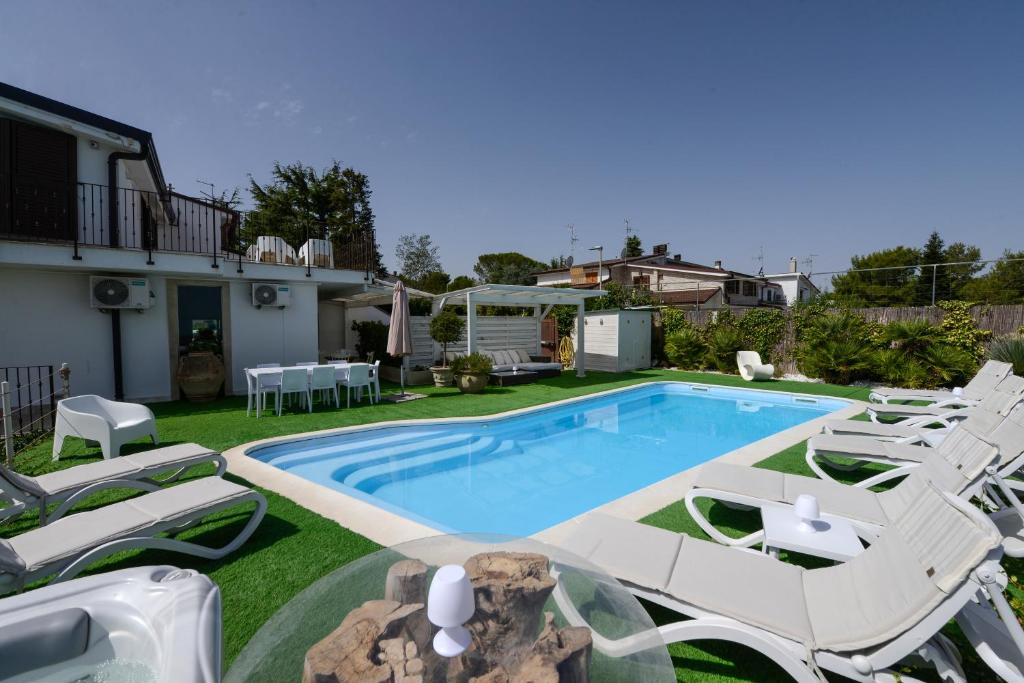 una piscina con sedie a sdraio e una piscina di In Villa Cielo a Cassano delle Murge