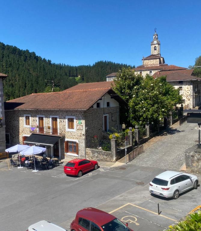a parking lot with cars parked in front of a building at Aramotz Etxea in Ugarana