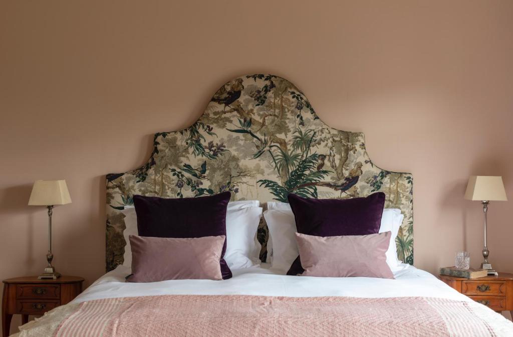 a bedroom with a large bed with a large headboard at The Knowle at St Leonards in St. Leonards