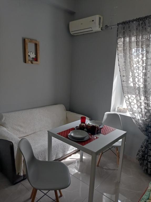 un piccolo soggiorno con tavolo e divano di MOSHOVIA STUDIO Κάρπαθος στο κέντρο και ήσυχα a Karpathos