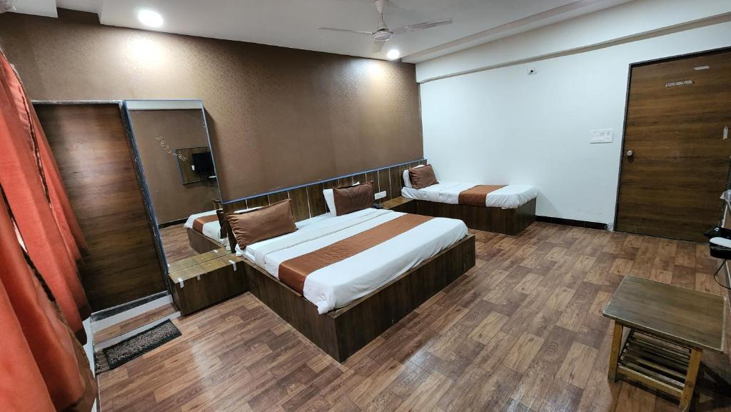 Habitación de hotel con cama y espejo en Hotel Nova Prime, en Ahmedabad