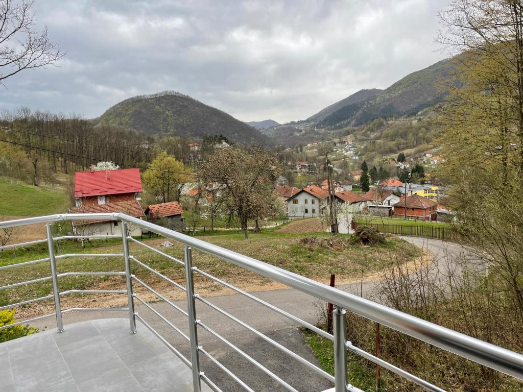 a balcony with a view of a town and mountains at Porodicna kuca za odmor Kovaci in Zavidovići