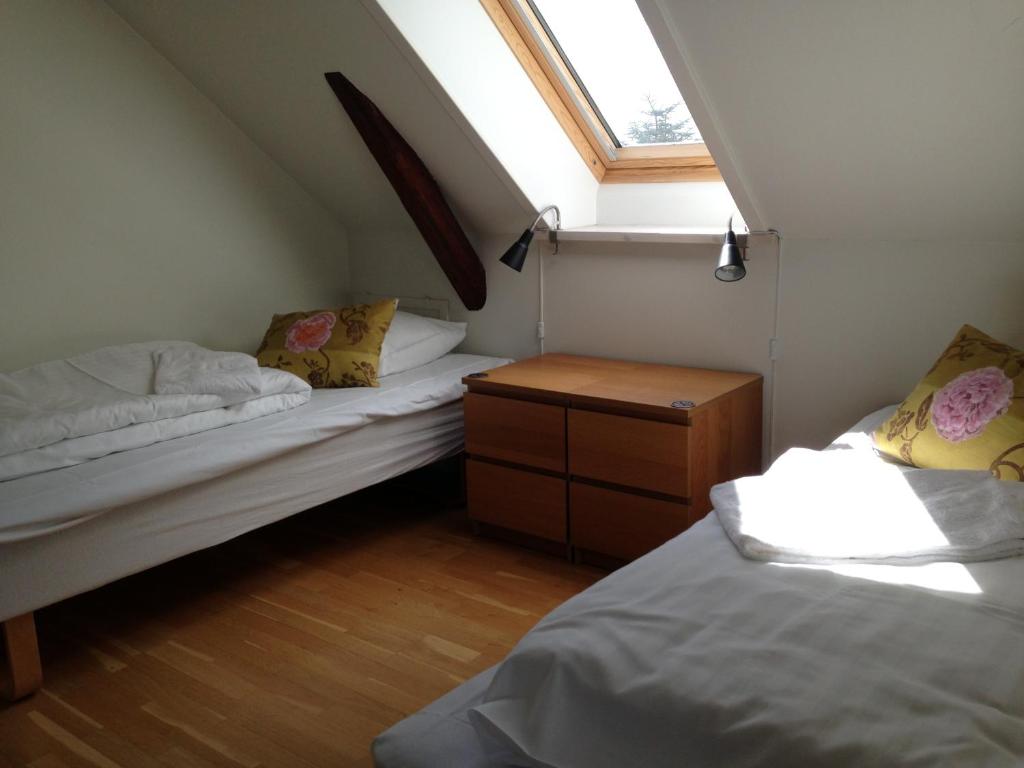 a attic room with two beds and a window at Kirke Saaby Forsamlingshus in Kirke Såby