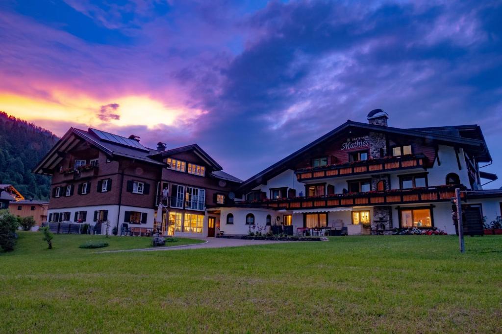 a large house with a sunset in the background at Gästehaus Mathies in Mittelberg