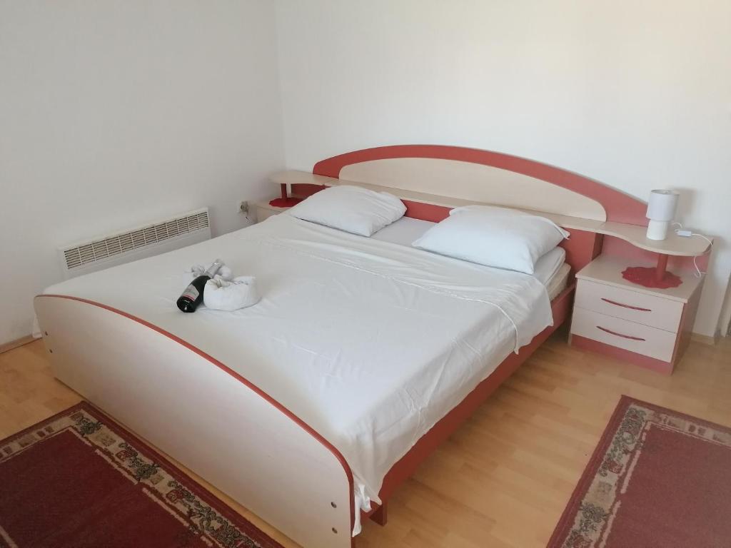 sypialnia z dużym białym łóżkiem z drewnianym zagłówkiem w obiekcie Tea w mieście Povljana