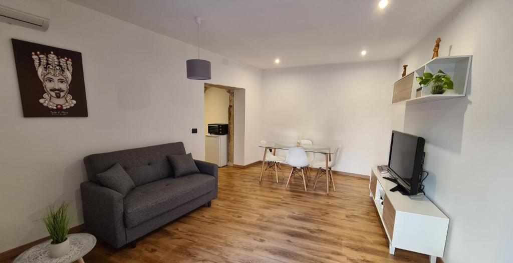 ein Wohnzimmer mit einem Sofa und einem TV in der Unterkunft Profumo Barocco 2 in Noto