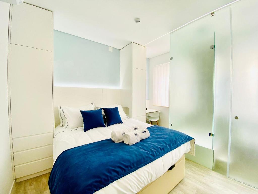 a bedroom with a blue and white bed with towels on it at Gloria 10 Deluxe in Lisbon