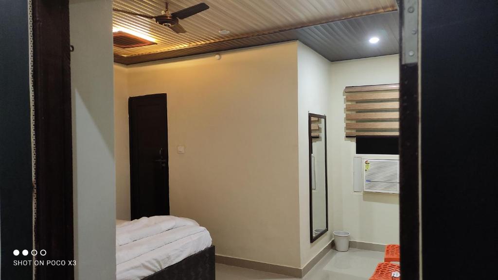 a bedroom with a bed and a ceiling fan at Arvind Conference Halls in Jhānsi