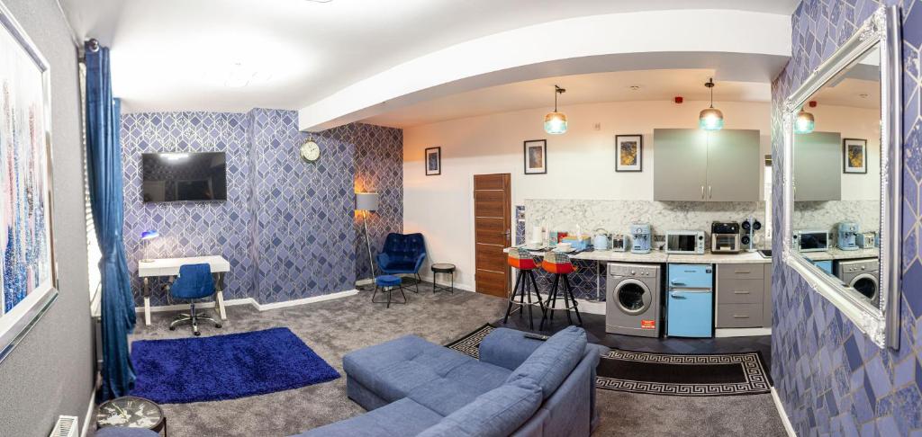 a living room with a blue couch and a kitchen at Cosy Luxury Suite Jewellery Quarter - Birmingham in Birmingham