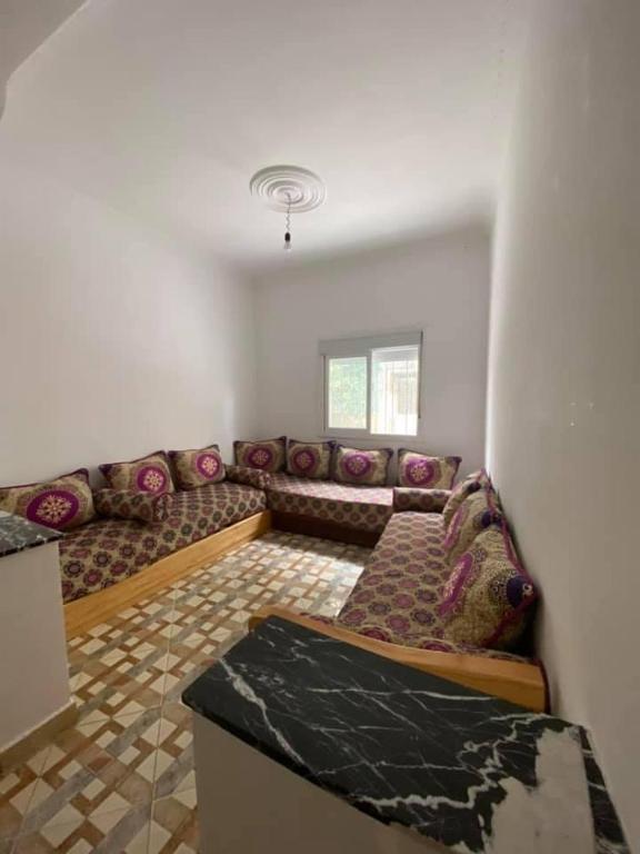 a living room with a long couch in a room at Appartement MARTIL BEACH 2 in Martil