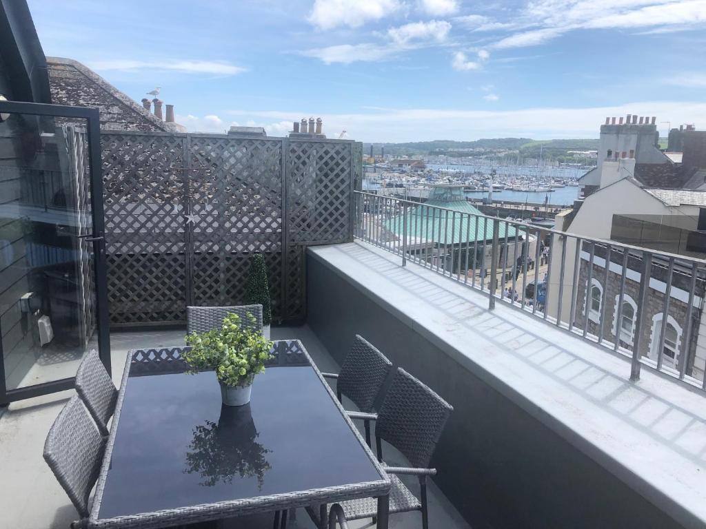 a table and chairs on a balcony with a view at The Barbican Penthouse in Plymouth