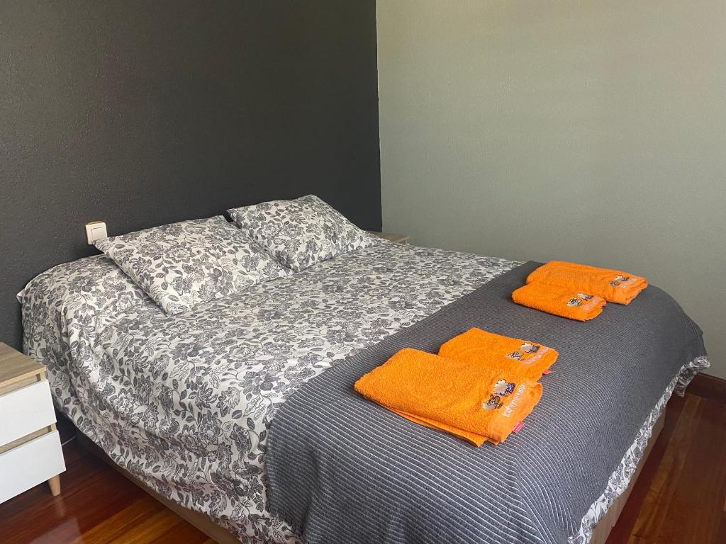 - un lit avec 2 serviettes orange dans l'établissement Amezola 2- Habitación con baño exterior de uso privado en casa compartida, à Bilbao