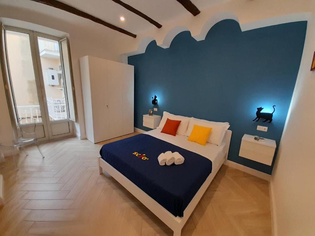 een slaapkamer met een bed met een blauwe muur bij Casa Sciò in Sorrento