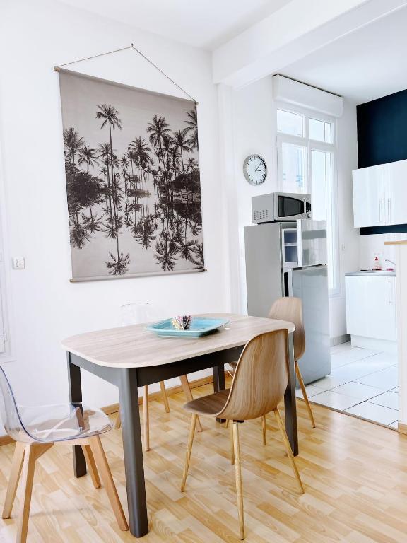 une cuisine et une salle à manger avec une table et des chaises dans l'établissement Le Balcon de Notre Dame Le Treport - Locations ISAHORA, au Tréport