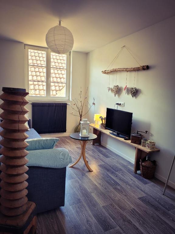 un salon avec un canapé et une télévision dans l'établissement A la Forge (proche d'Europapark), à Sermersheim