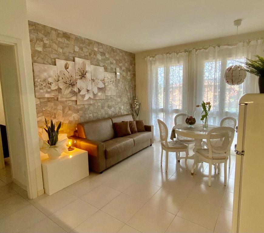 un soggiorno con divano, tavolo e sedie di Elena Apartment Residence a Bardolino