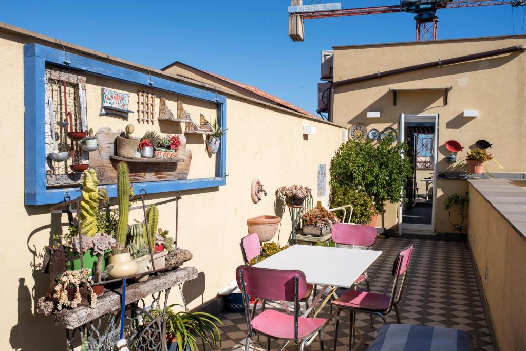 a patio with a table and chairs and plants at Terrazze Ginevra in Palermo