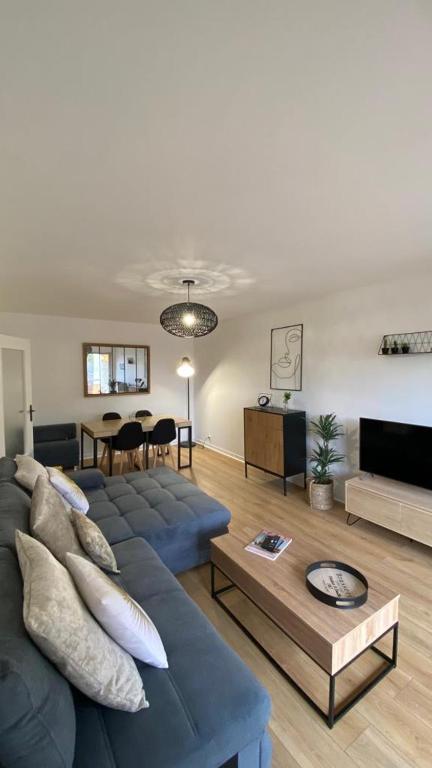 Location appartement F2 à Caen My precious Home F2 à Caen في كايين: غرفة معيشة مع أريكة زرقاء وطاولة