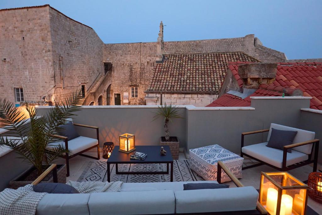 un patio con sofá y sillas en el techo en Villa inside the Old town with private terrace and floor heating en Dubrovnik