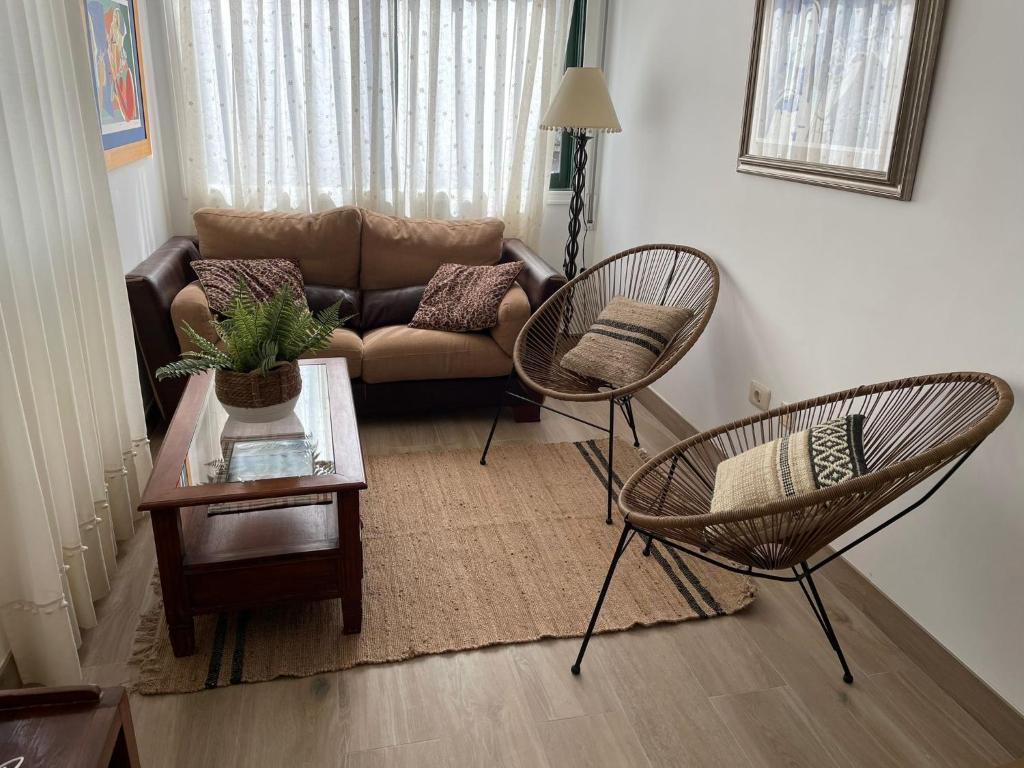 カンガス・デ・モラソにあるMi casita de Cangasのリビングルーム(ソファ、椅子2脚、テーブル付)