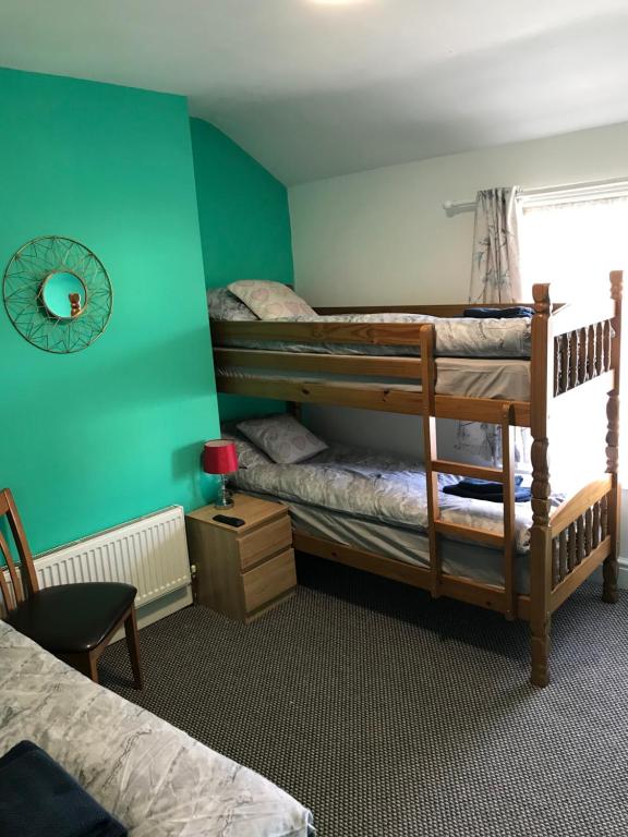 two bunk beds in a room with green walls at Yado Hotel in Blackpool