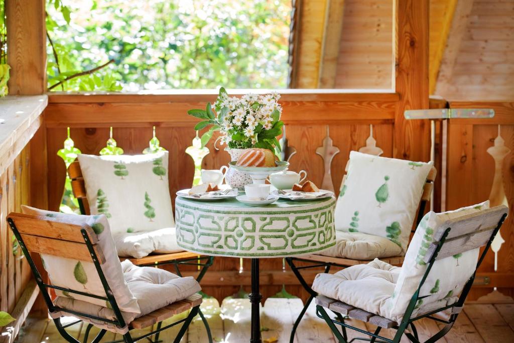 una mesa y sillas en un porche con una mesa y tazas en Garden Cottage Villa Lichtenstein en Altaussee