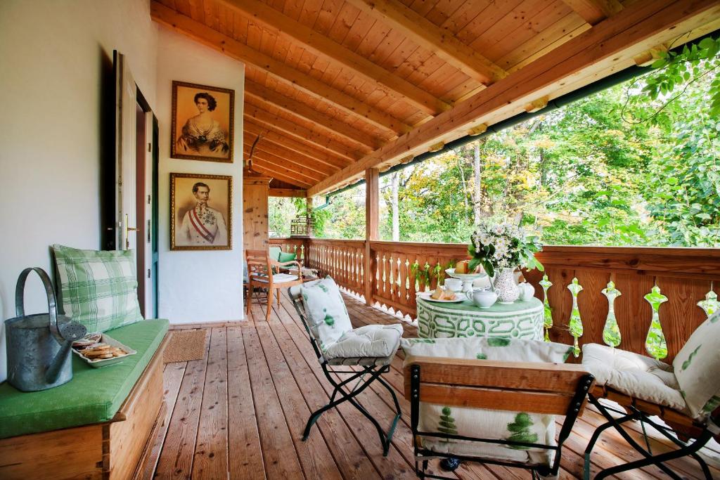 a screened in porch with a table and chairs at Garden Cottage Villa Lichtenstein - Your Austrian Home in Altaussee
