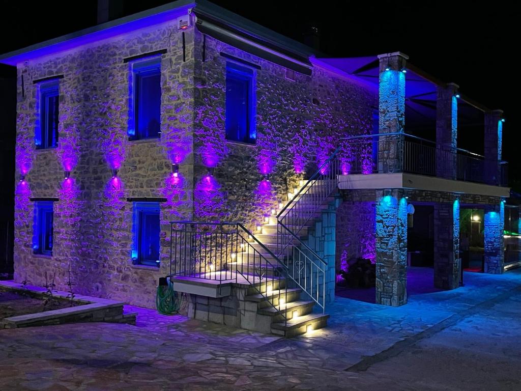 ein Gebäude mit lila Lichtern an der Seite in der Unterkunft ΒΙΛΛΑ ΤΟ ΠΕΤΡΙΝΟ stone bild villa full equipment in Nafpaktos