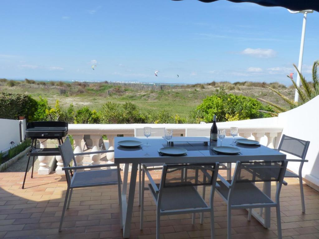 une table et des chaises sur une terrasse avec vue dans l'établissement Sol-y-Days Flamant, Superbe appartement en rez de jardin avec grande terrasse et jardinet, face a la mer, au Grau-du-Roi