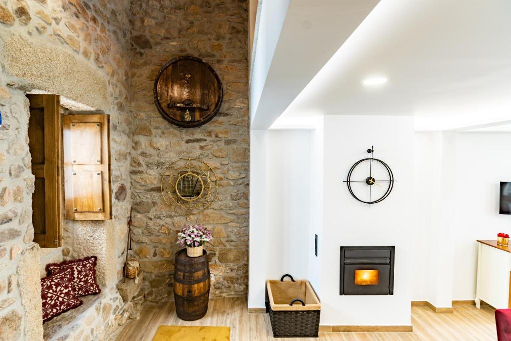 a living room with a stone wall and a fireplace at Adega do Balé in Miranda do Douro