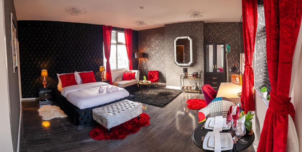 ein Schlafzimmer mit einem Bett und ein Zimmer mit roten Vorhängen in der Unterkunft Opulent 1 Bedroom Cosy Suite in Birmingham