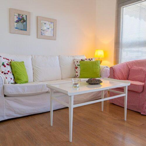 a living room with a white couch and a table at Alemar Estates Agia Triada in Agia Triada