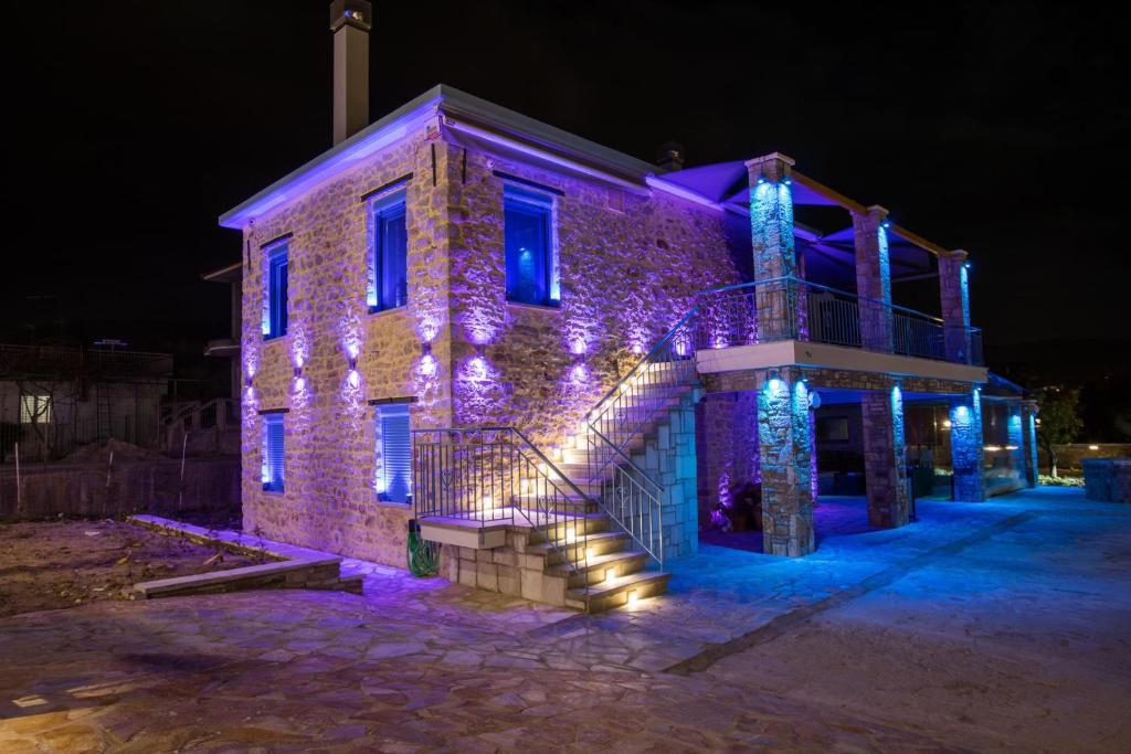 ein Gebäude mit lila Lichtern in der Nacht in der Unterkunft ΒΙΛΛΑ ΤΟ ΠΕΤΡΙΝΟ stone bild villa full equipment in Nafpaktos