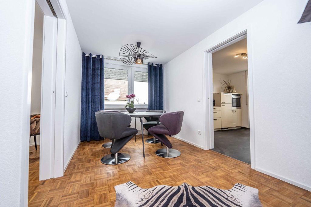 uma sala de estar com mesa e cadeiras e uma cozinha em City Wohnung FN L 5 KLIMATISIERT mit Balkon und Küche em Friedrichshafen