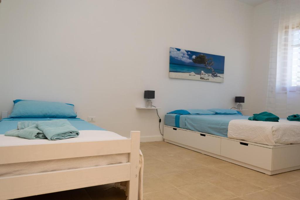 une chambre avec deux lits et un tableau au mur dans l'établissement Villa Perilli - Luxury Stay con piscina privata, à Diso 36 autres photos