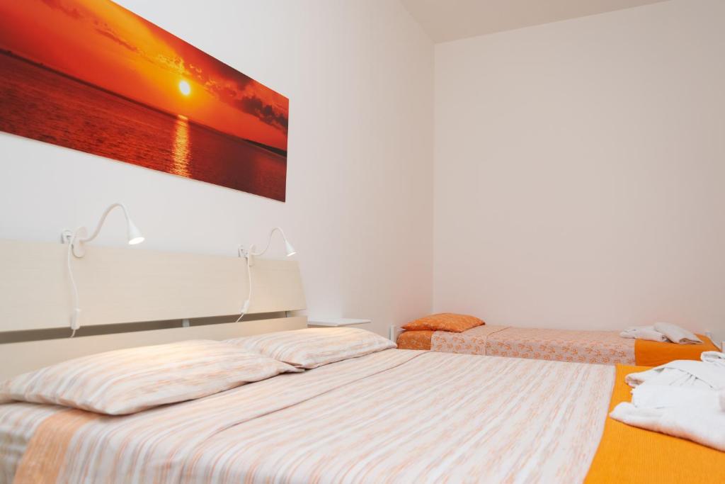 une chambre avec deux lits et un tableau au mur dans l'établissement Villa Perilli - Luxury Stay con piscina privata, à Diso