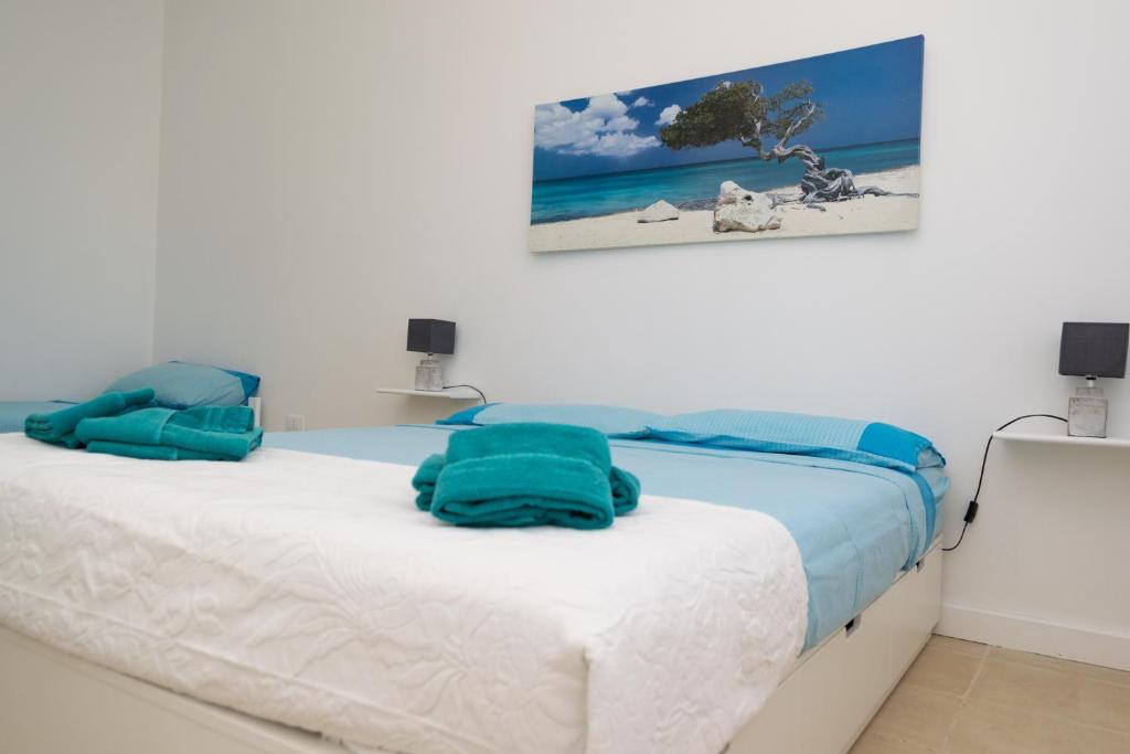 une chambre avec un lit recouvert de serviettes bleues dans l'établissement Villa Perilli - Luxury Stay con piscina privata, à Diso