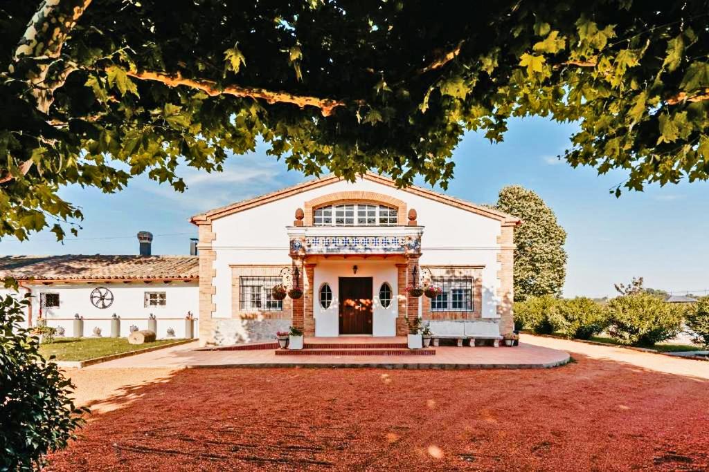 uma grande casa branca com um grande jardim da frente em Torre Graells em Balaguer