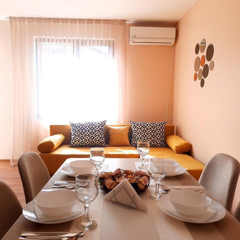 mesa de comedor con sillas y mesa con copas de vino en Апартамент Лидия en Chepelare