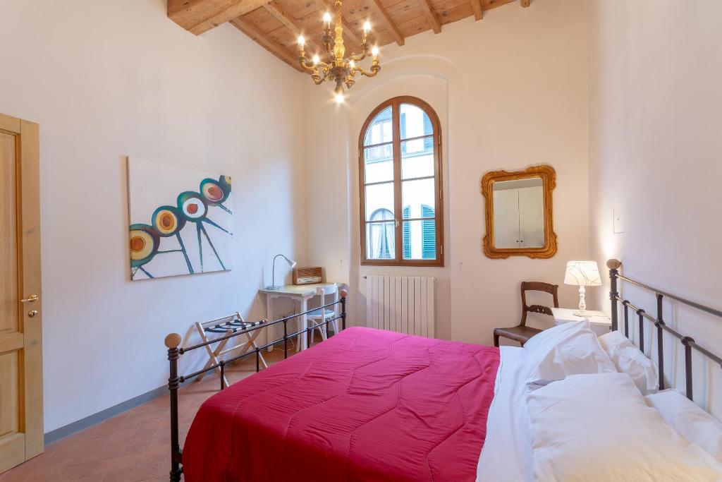 Schlafzimmer mit einem Bett, einem Fenster und einem Spiegel in der Unterkunft Sant'Agostino Apartments in Florenz