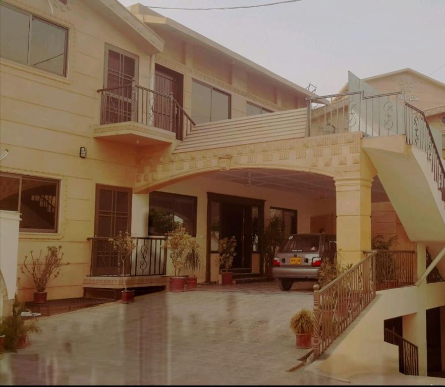 une maison avec un balcon et une voiture garée devant dans l'établissement Luxury Palace Peshawar, à Peshawar