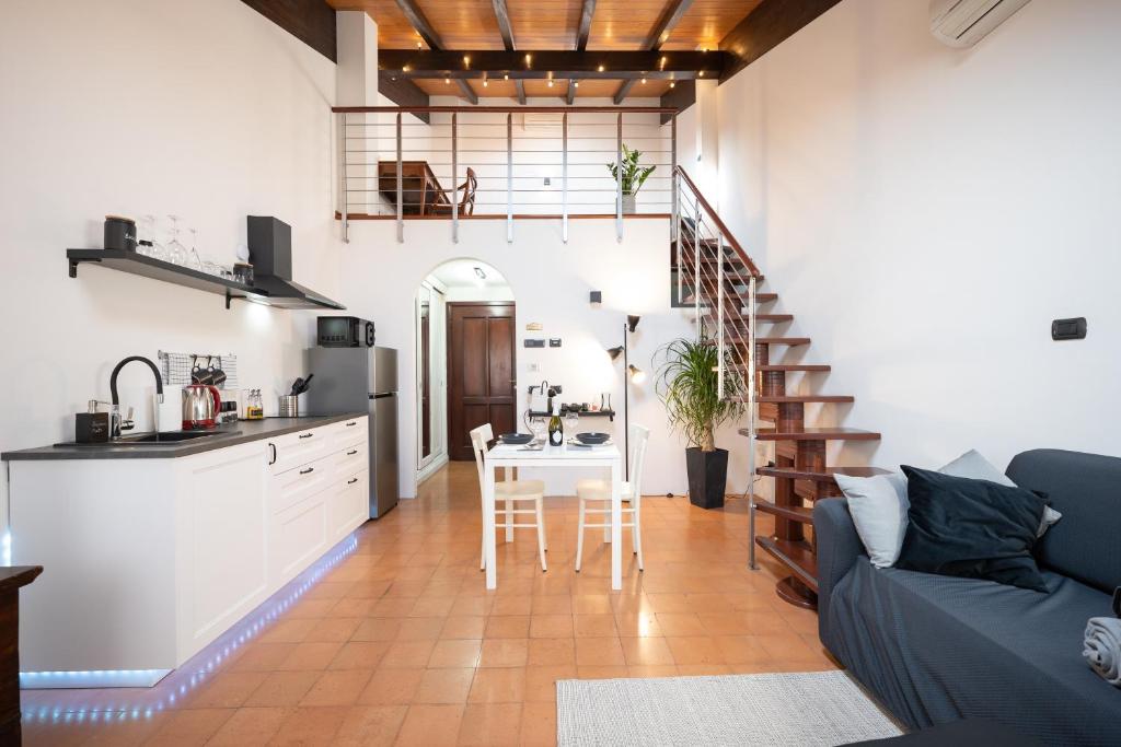 [Chardonnay]- elegante appartamento في Cavezzo: مطبخ وغرفة معيشة مع أريكة وطاولة